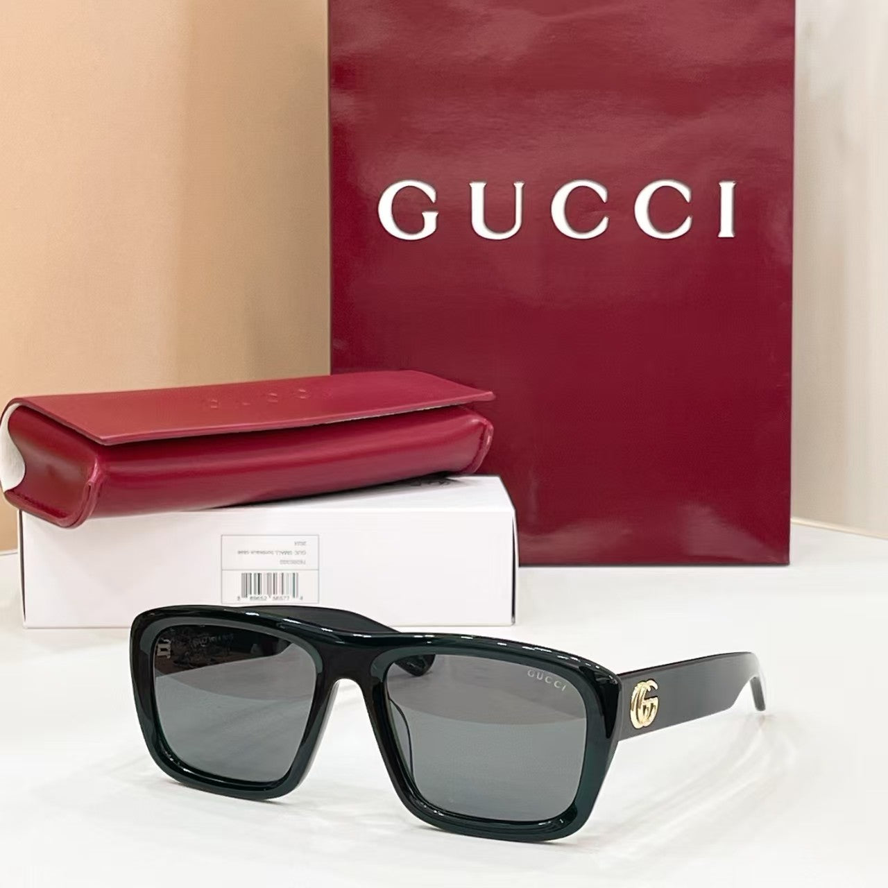 Shop luxury Gucci square sunglasses with iconic gold Double G logo. Glossy black acetate frame, UV400 polarized lenses, unisex design for driving, travel & daily streetwear. Comes with original Gucci box, case & packaging. Free worldwide shipping.